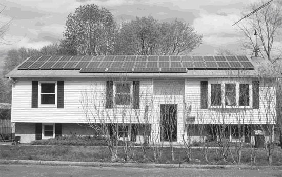 Brentwood, Long Island home with solar panels, facing west with more panels on the roof’s eastern slope.